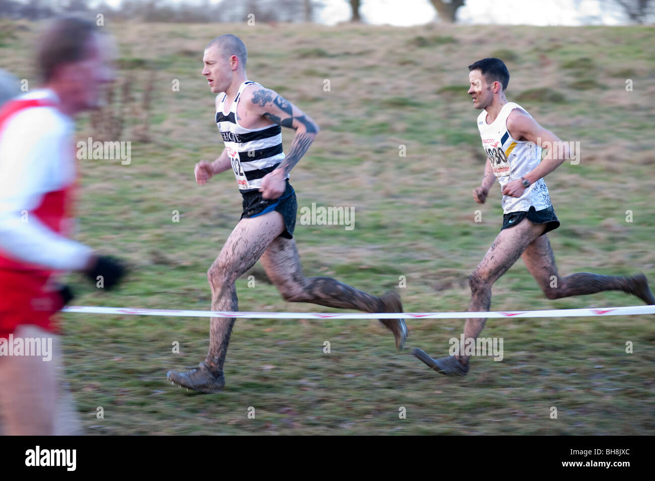 Un tatoué runner éclaboussés de boue dans une course de cross-country à la colline du Parlement Banque D'Images