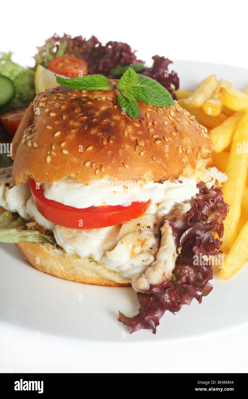 Un burger de poisson - un filet de poisson frit dans un petit pain avec une salade et frites Banque D'Images