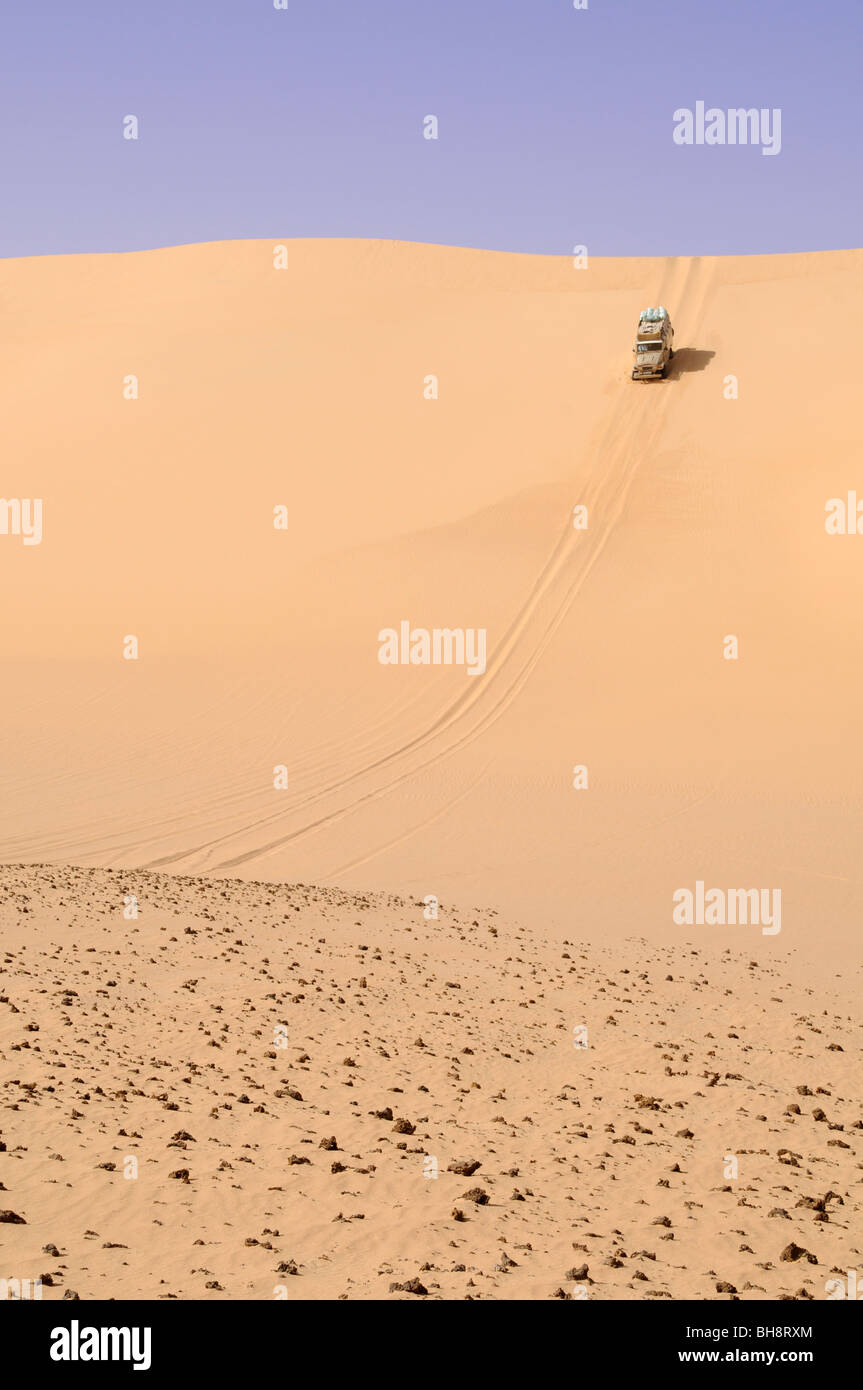 Un désert safari Land cruiser 4x4 Jeep écussons une dune de sable géant dans la grande mer de sable du désert occidental, Sahara Égyptien, l'Egypte. Banque D'Images