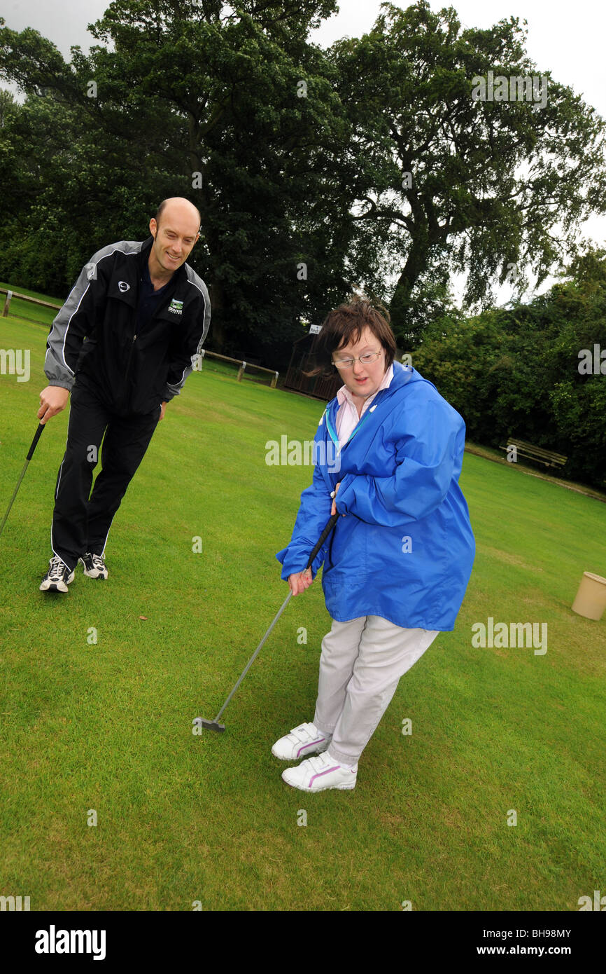 Deux femmes ayant des troubles d'apprentissage jouer pitch and putt, North Yorkshire Banque D'Images