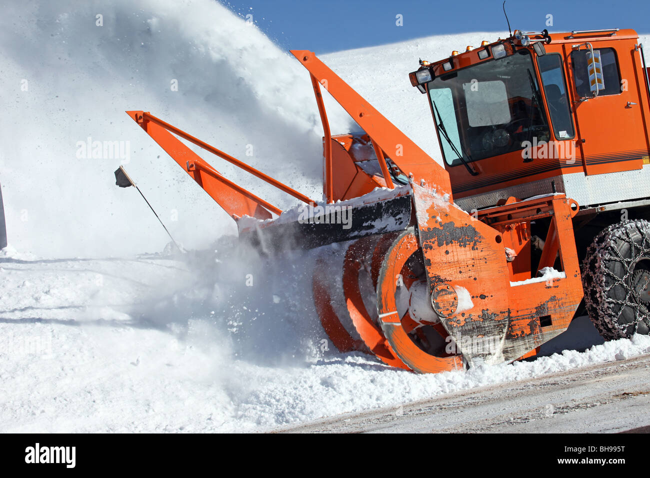Enlever la neige de la souffleuse à neige à partir de la route de montagne.  Les véhicules larges pales tournant avec lance la glace et la neige sur les  routes. Pas d'emblème
