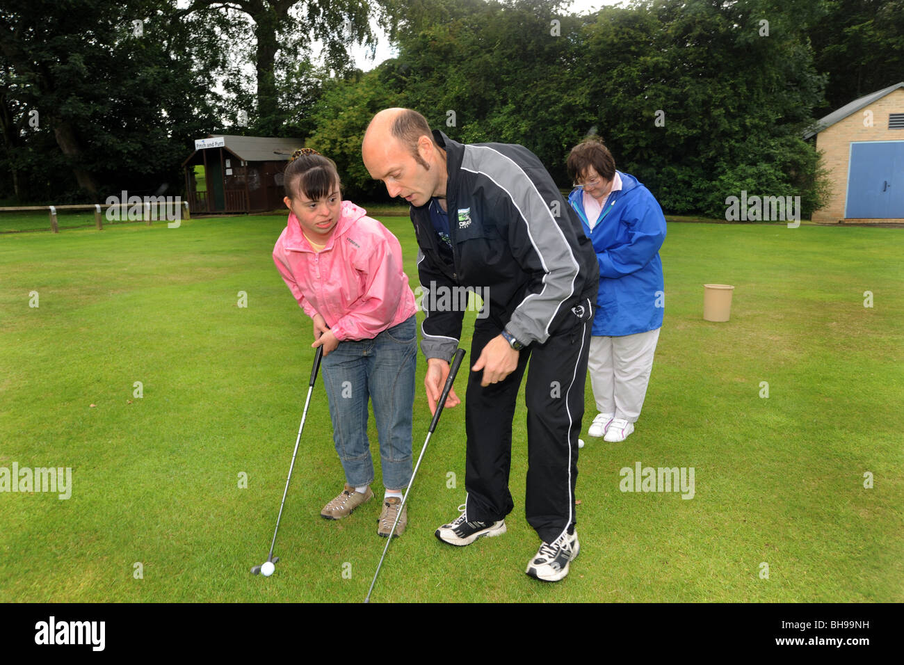 Deux femmes ayant des troubles d'apprentissage jouer pitch and putt, North Yorkshire Banque D'Images