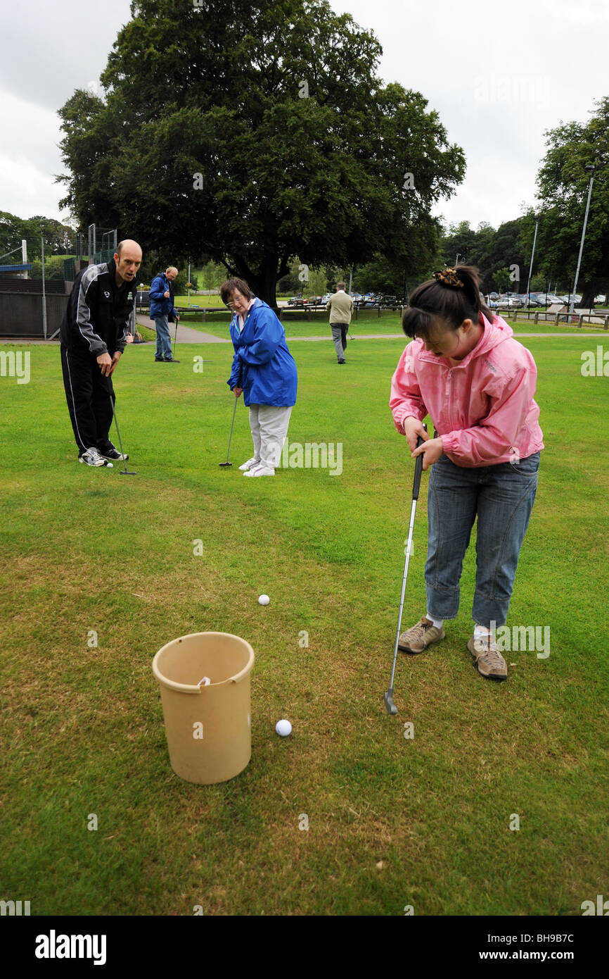 Deux femmes ayant des troubles d'apprentissage jouer pitch and putt, North Yorkshire Banque D'Images