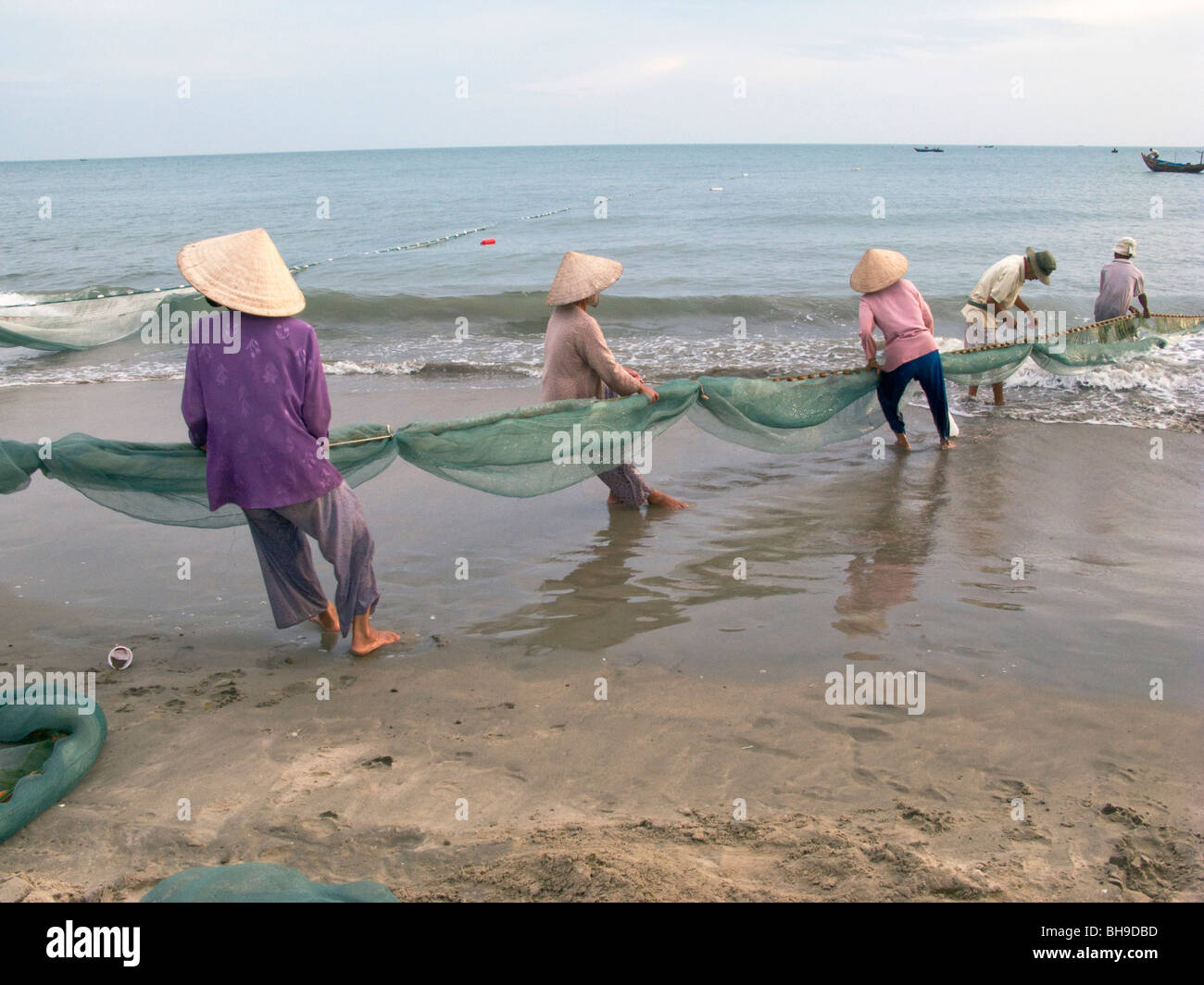 Les FEMMES DU VIETNAM À PARTIR DE LA COOPÉRATIVE DE PÊCHE CASTING NET DANS LA MER PRÈS DE MUI NE Banque D'Images