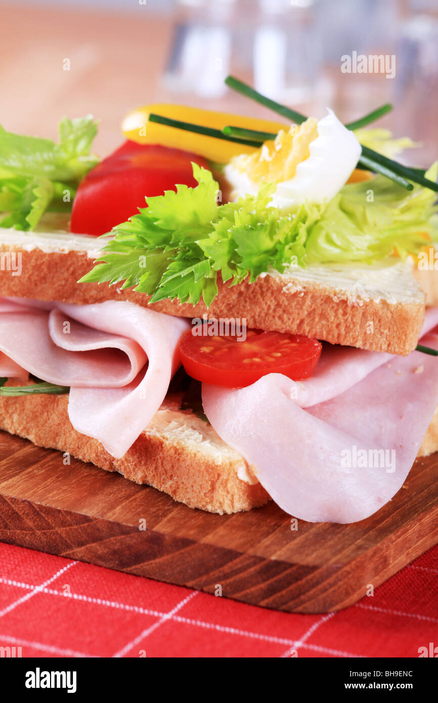 Détail d'un sandwich au jambon sur une planche à découper Banque D'Images