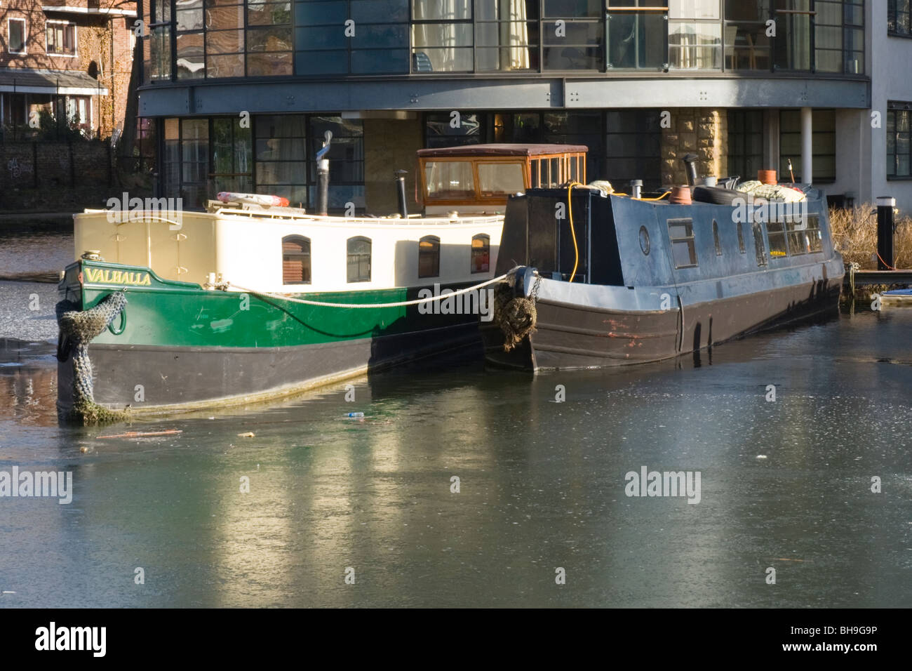 , Un bateau long Narrowboats ou péniches ou bateaux dans le bassin Battlebridge de Regent's Canal avec de l'eau glacé et gelé sur glace Banque D'Images