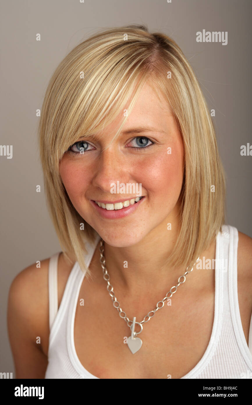 A la tête d'une des épaules d'un adolescent blond avec un bob portant un gilet blanc dessus. Banque D'Images