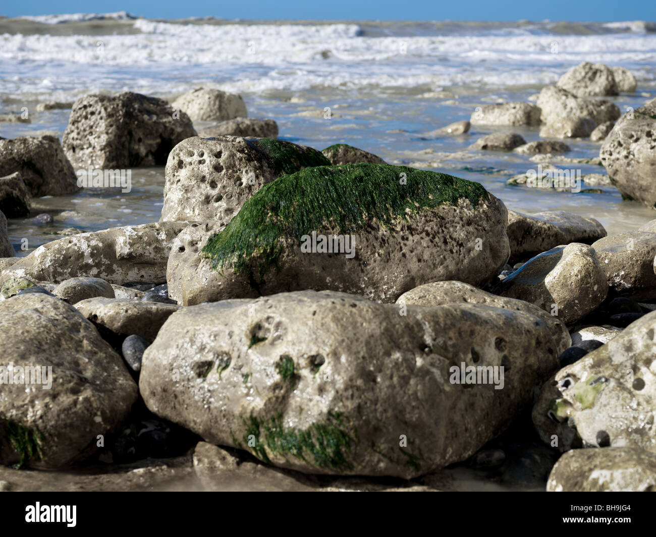 Vagues déferlant sur le littoral parsemé de rochers de craie. Banque D'Images