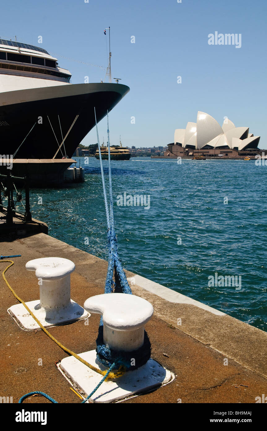 Sydney Opera House Cruise Ship Circular Quay Sydney Australie // SYDNEY, Australie — Un grand bateau de croisière est amarré à Circular Quay, à côté du quartier des Rocks, avec l'Opéra de Sydney en arrière-plan. Des lignes d'amarrage sécurisent le navire au quai, tandis qu'un ferry navigue dans les eaux scintillantes du port de Sydney. Banque D'Images