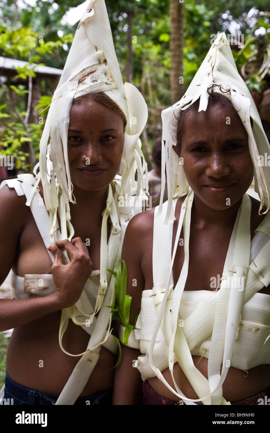 Deux jeunes femmes mélanésiennes traditionnelles portant la tête blanche robe et costume île sourire dans l'appareil photo Banque D'Images