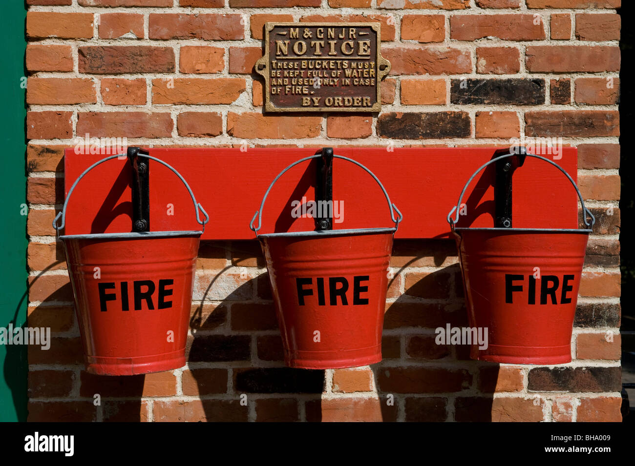 Seaux d'incendie rouge pendaison sur mur de brique Banque D'Images