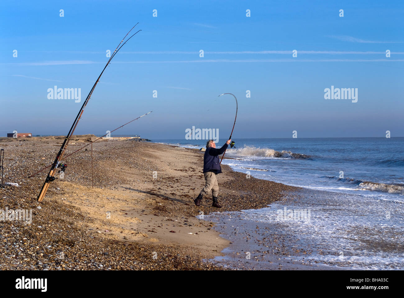 Fisherman casting avec roulettes plage mer canne à pêche à benacre suffolk angleterre Banque D'Images