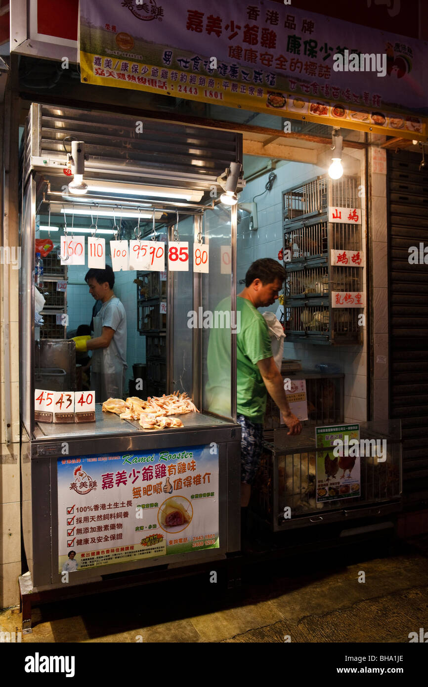 Un poulter met en place dans la boutique earl matin sur Wanchai Road street market à Hong Kong. Banque D'Images