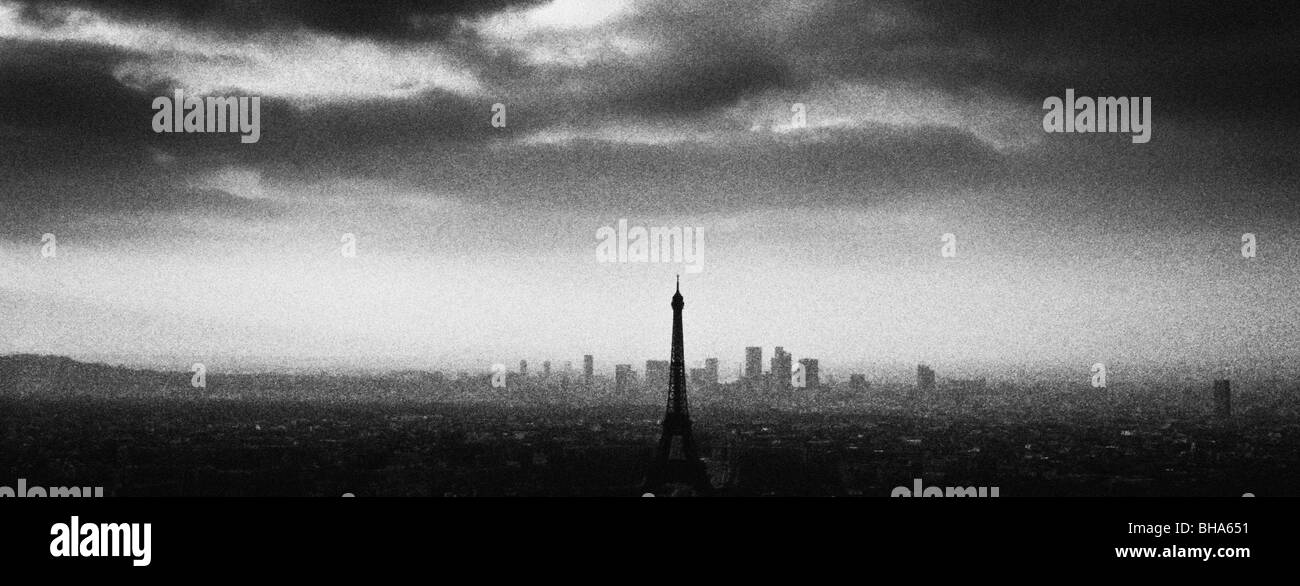 Vue panoramique monochrome granuleuse de la Tour Eiffel, tachée sur les toits de Paris. Tourné de la Tour Montparnasse à Paris Banque D'Images