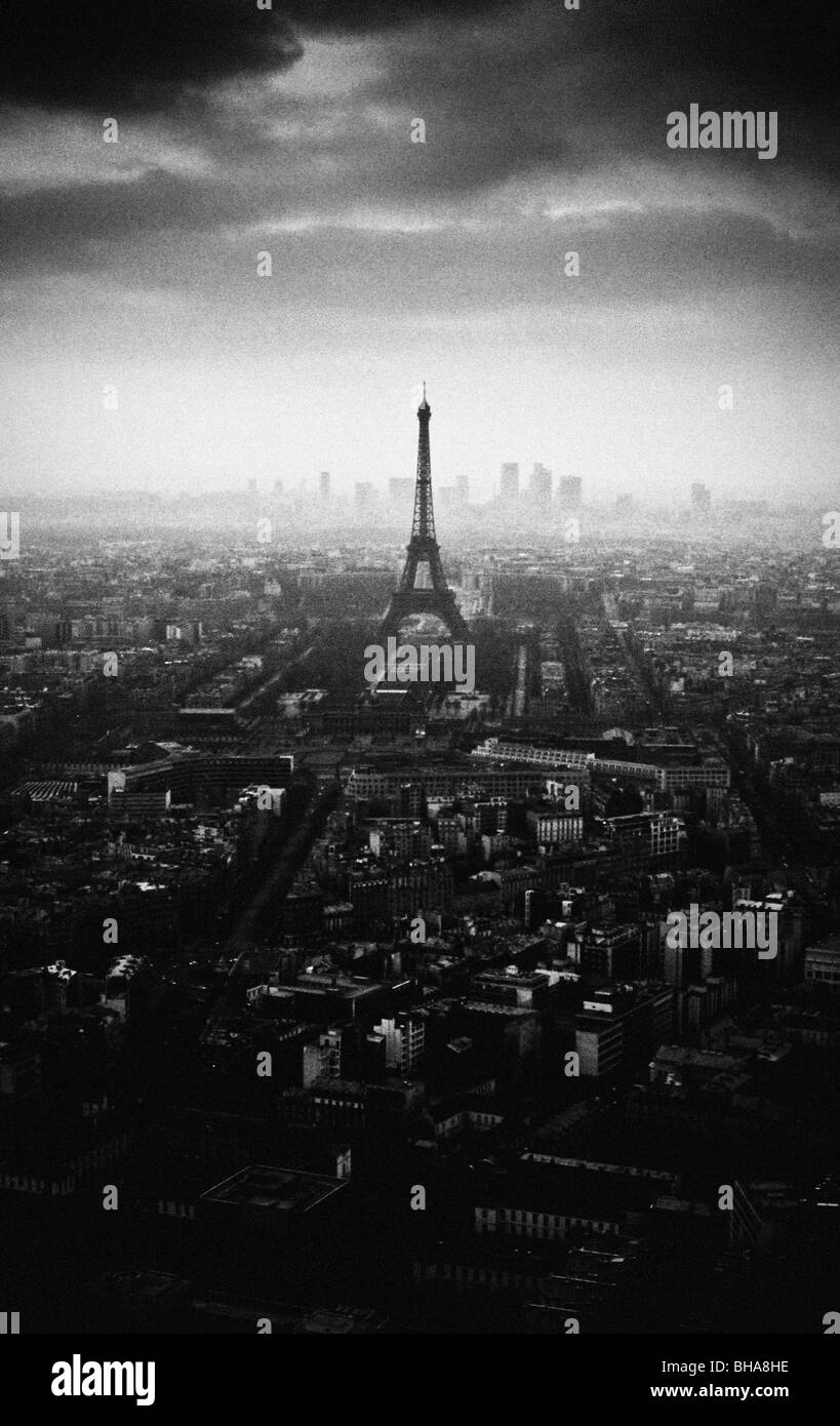 Image monochrome granuleuse de la Tour Eiffel silhouetée sur les toits de Paris. Banque D'Images