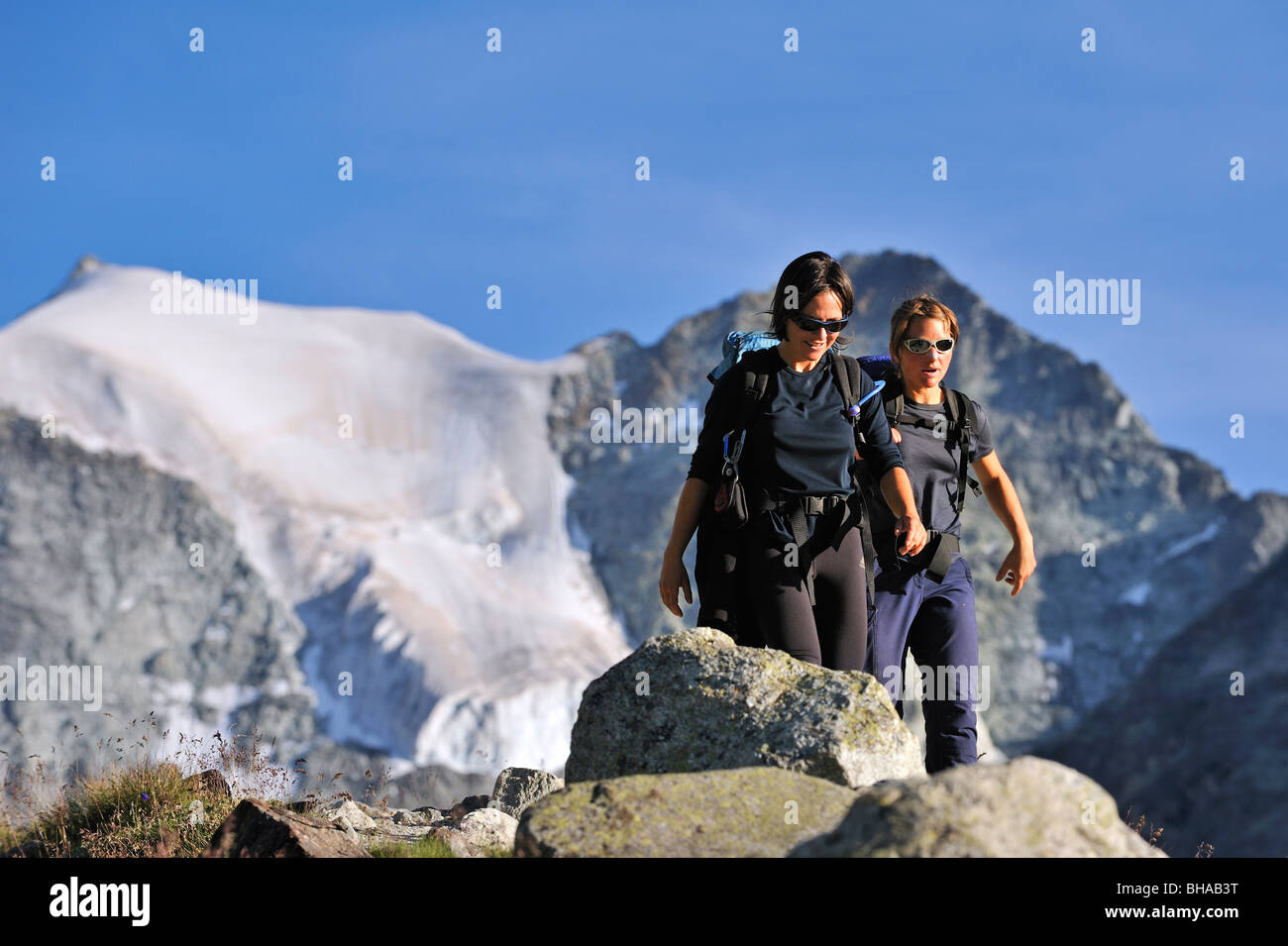 Deux Randonneurs marchant le long chemin de montagne dans les Alpes Pennines / Walliser Alpen, Valais / Wallis (Suisse) Banque D'Images
