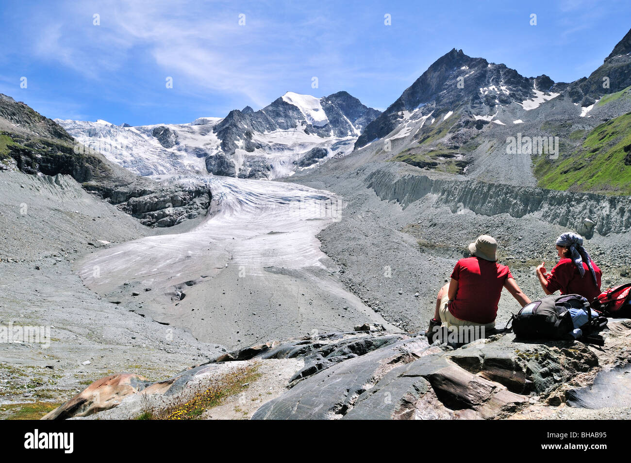 Les marcheurs / les randonneurs se reposant avec vue sur le glacier de Moiry en retraite, Alpes Pennines / Walliser Alpen, Valais / Wallis (Suisse) Banque D'Images