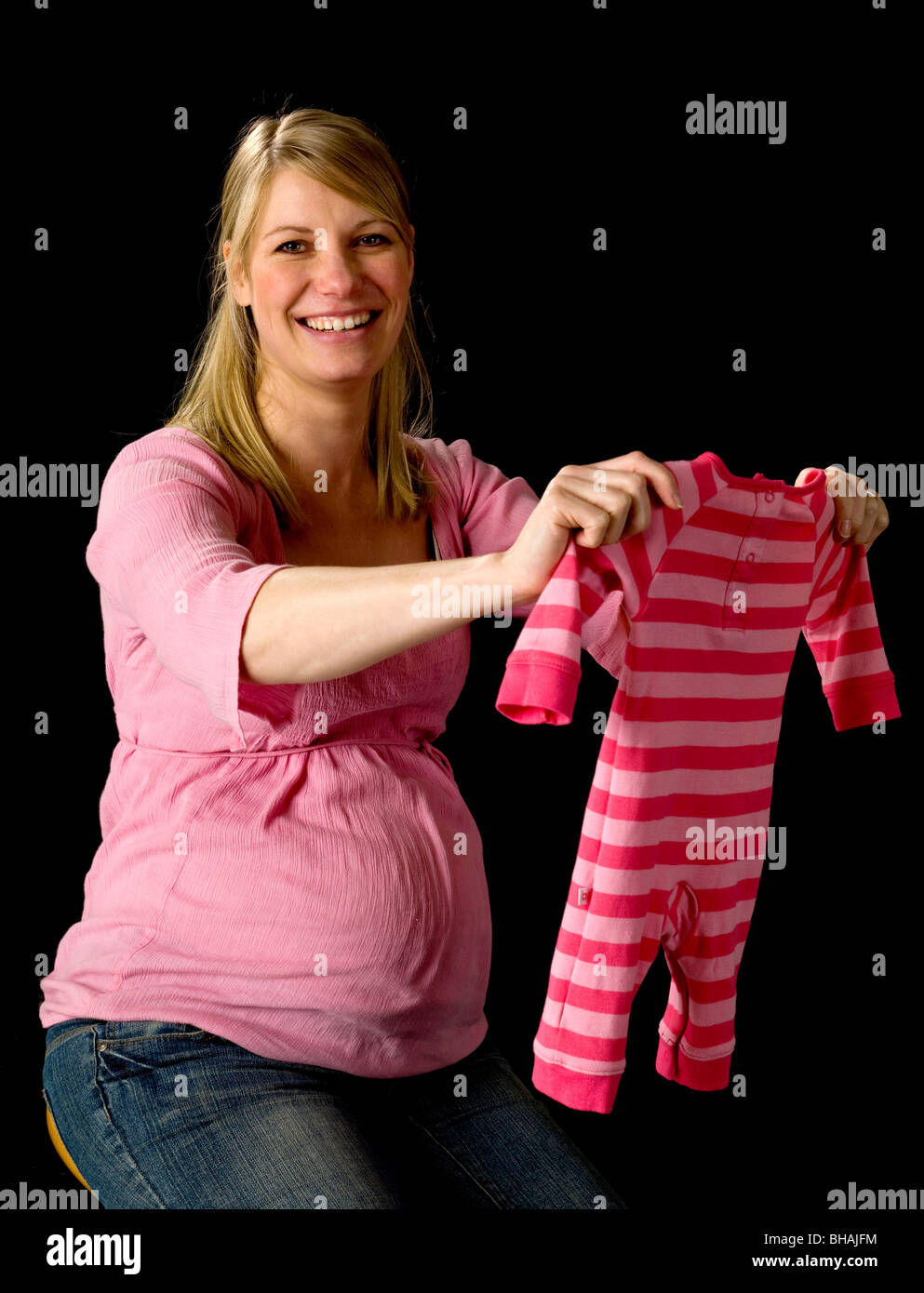 Pregnant Woman holding vêtements de bébé Banque D'Images