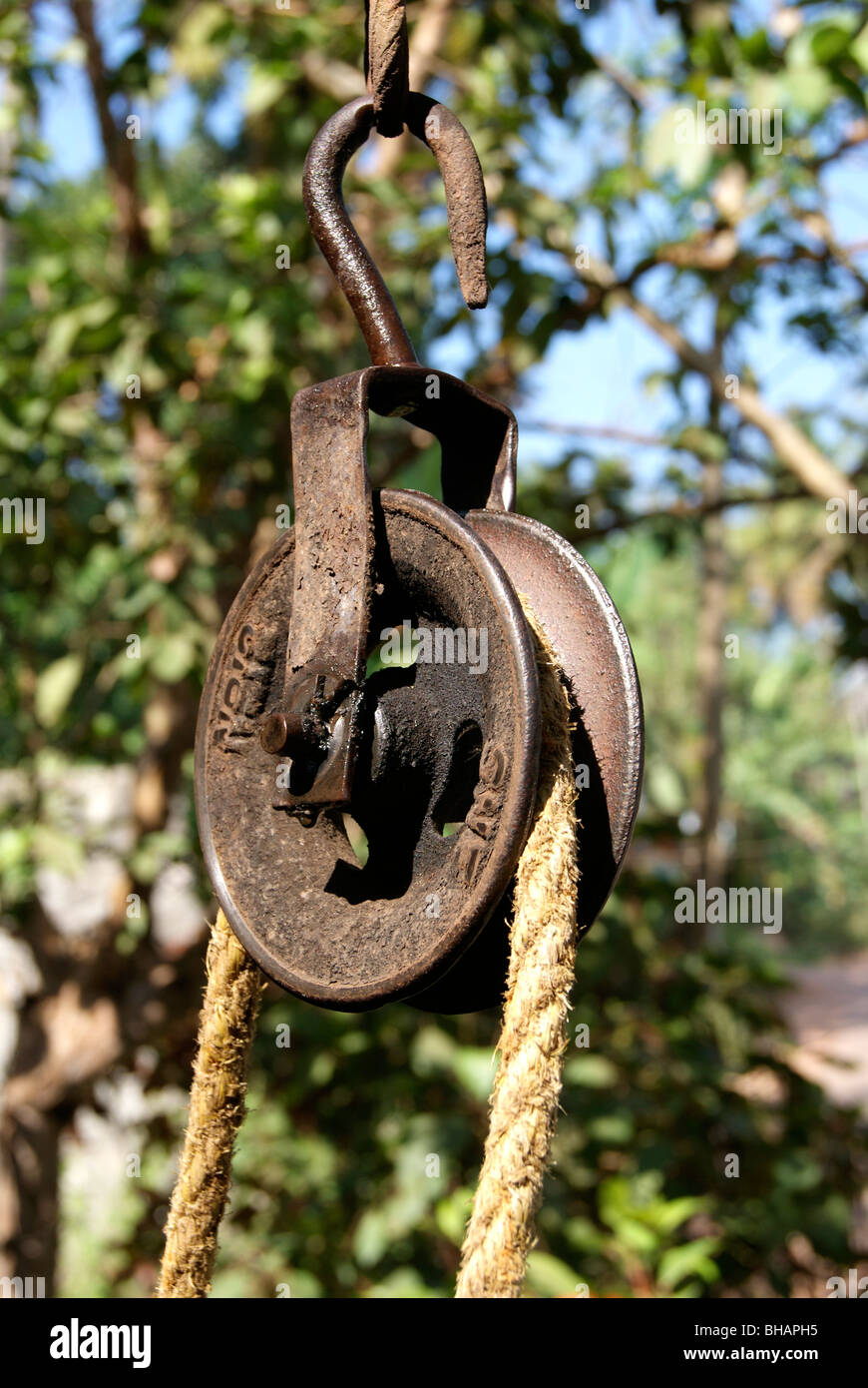 Un vieux puits avec un mécanisme de levage, une corde est enroulée sur une  roue en bois. Recouvert de pierres avec un toit en bois Photo Stock - Alamy