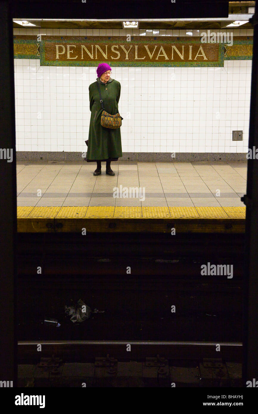 Femme en attente, Pennsylvania Station plate-forme du métro, New York City Banque D'Images