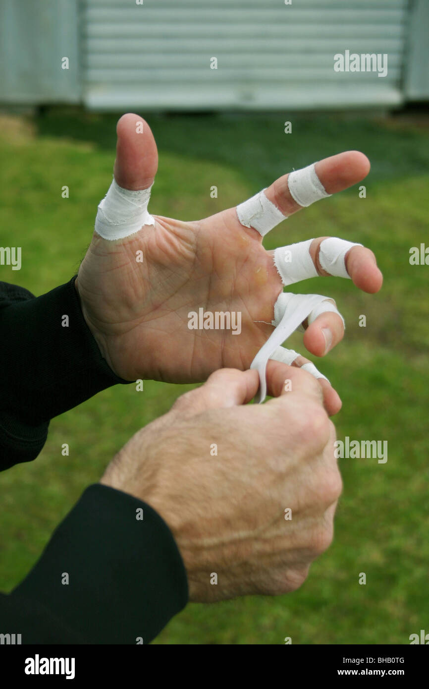 Gardien de la bande de bande médicale utilise ses doigts pour l'effectif  avant un match de football Photo Stock - Alamy