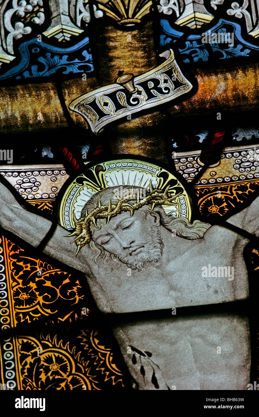 Détail d'un vitrail par Charles Kempe représentant Jésus crucifié, l'église de St Cuthbert, Kildale, Yorkshire du Nord Banque D'Images