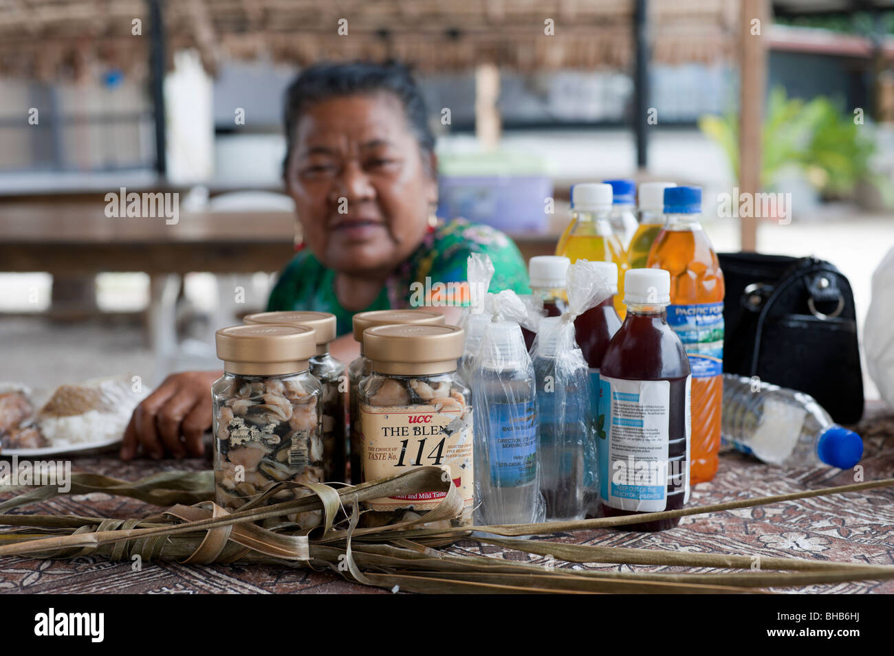 Une femme vend des produits locaux des Îles Marshall (huile de noix de coco séchées, palourdes, jus de pandanus) au marché local de Majuro (Îles Marshall) Banque D'Images