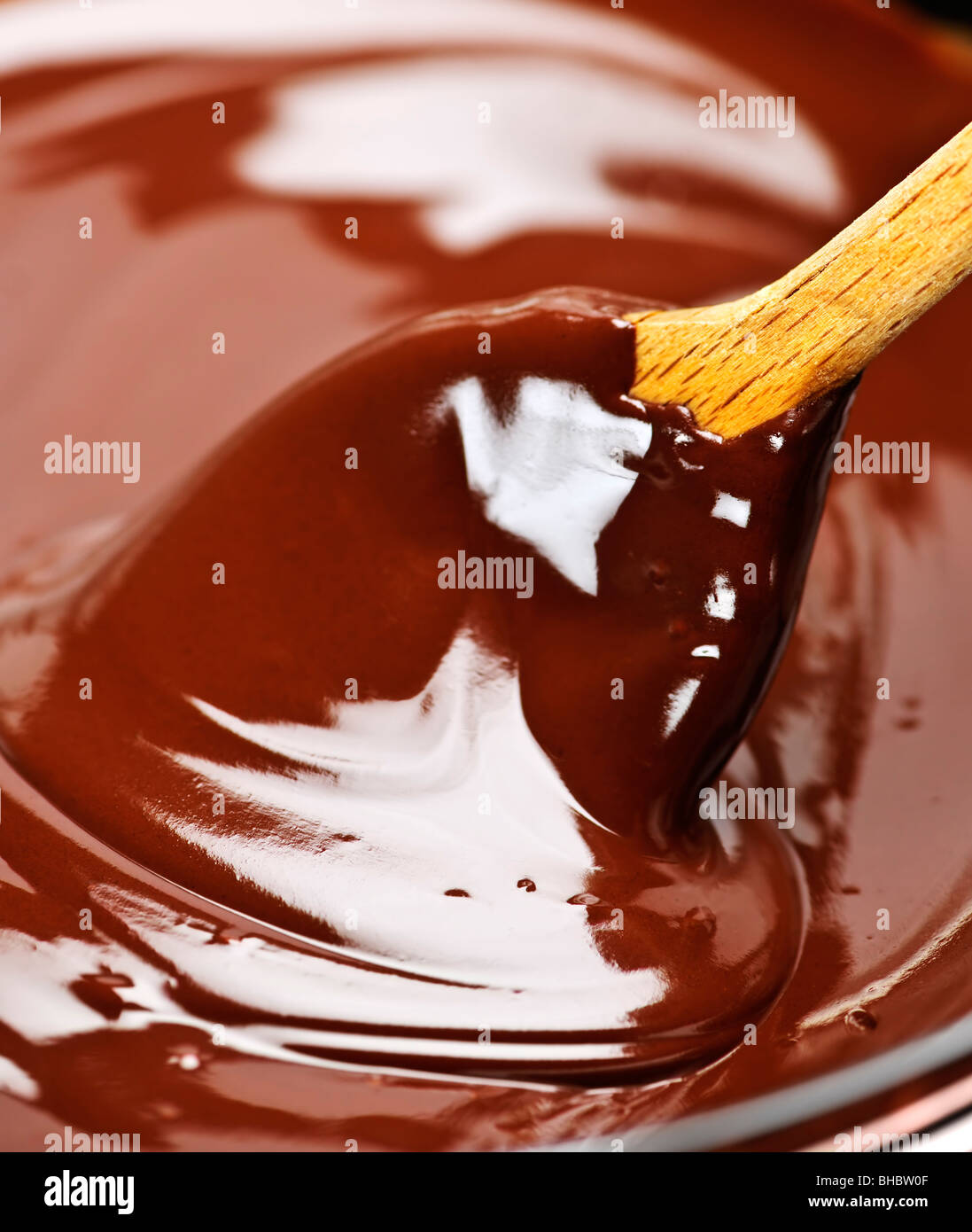 Cuillère en bois chocolat fondu doux en remuant Banque D'Images