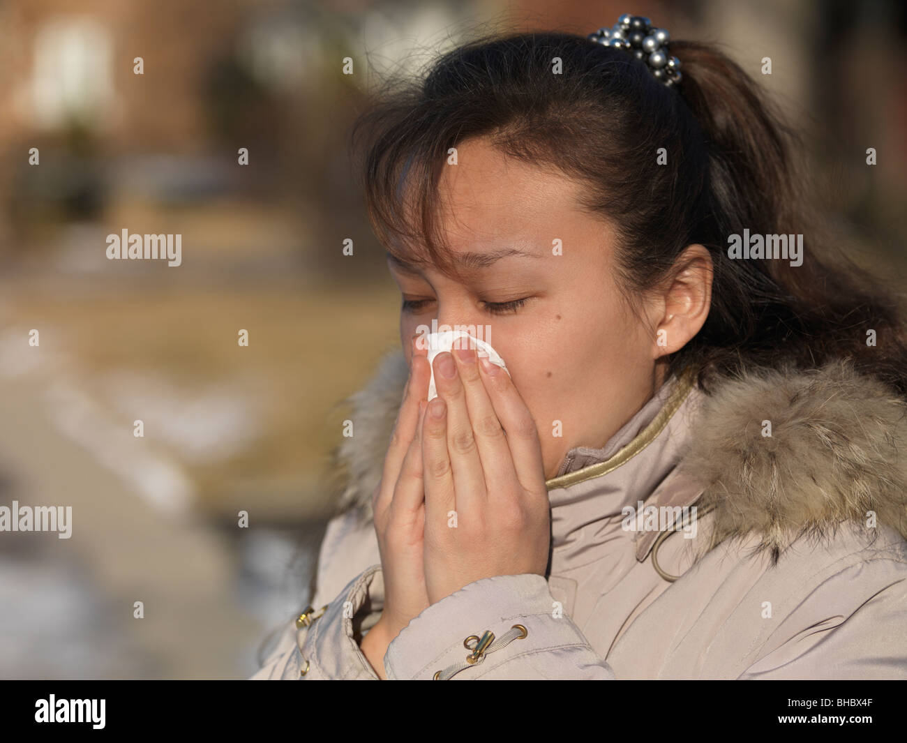 Woman blowing son nez à l'extérieur en hiver Banque D'Images