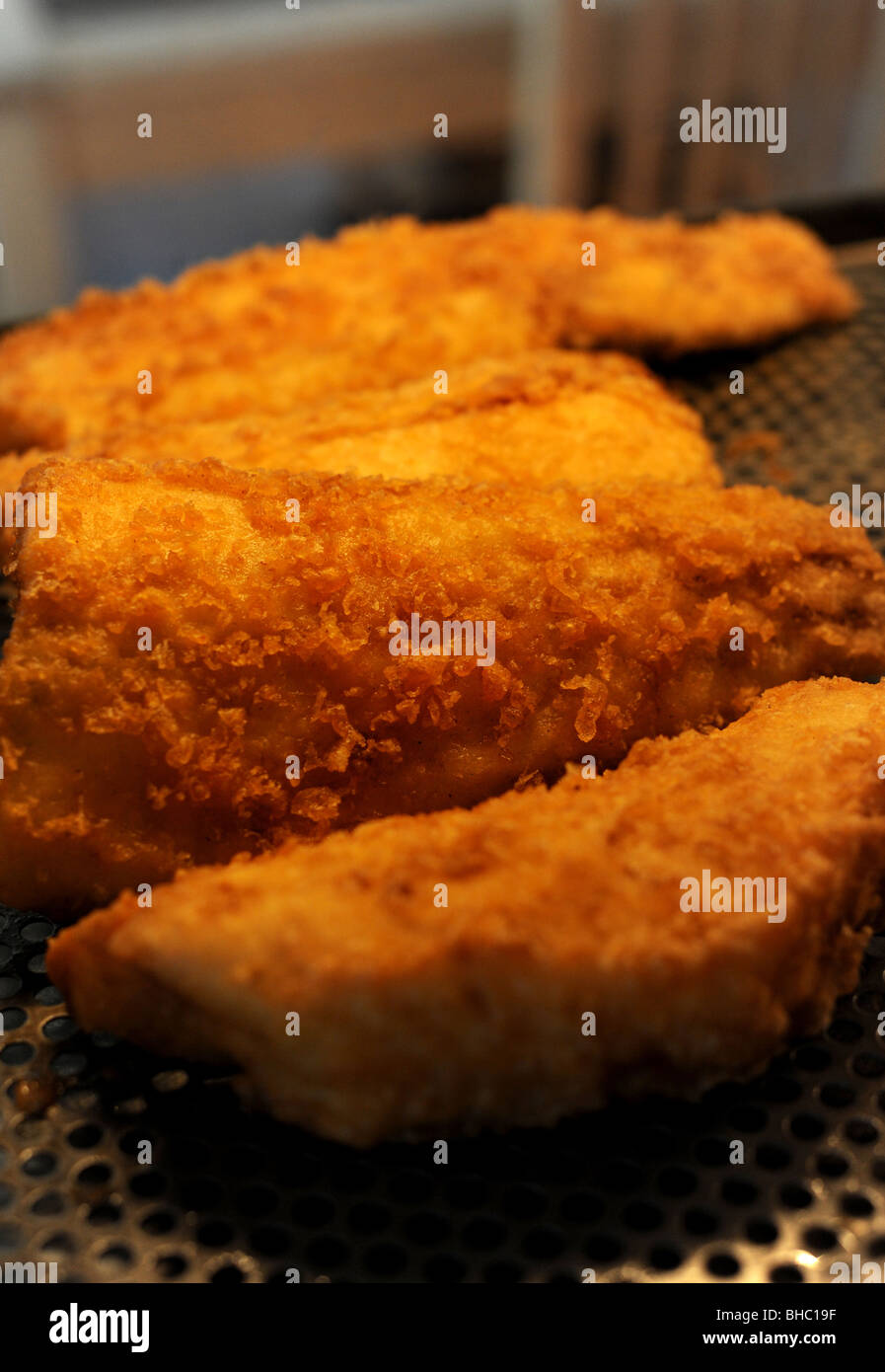 Des portions de Cabillaud frit dans une pâte dans l'armoire chaude dans un poisson et chip shop Banque D'Images