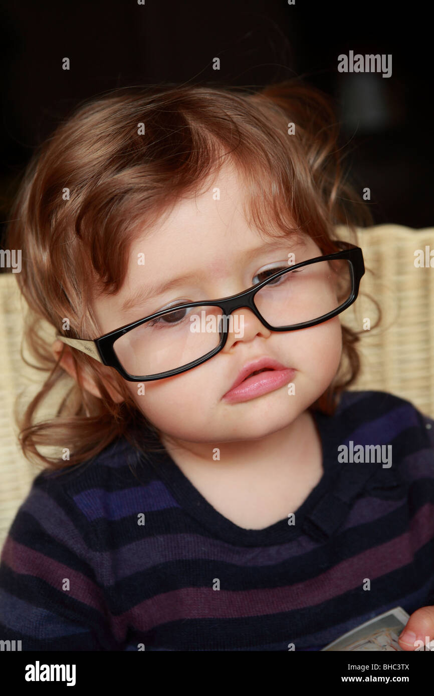 Une petite fille de vingt mois, ce qui signifie qu'elle lit pour du vrai  avec de faux verres un livre du philosophe français Albert Camus Photo  Stock - Alamy