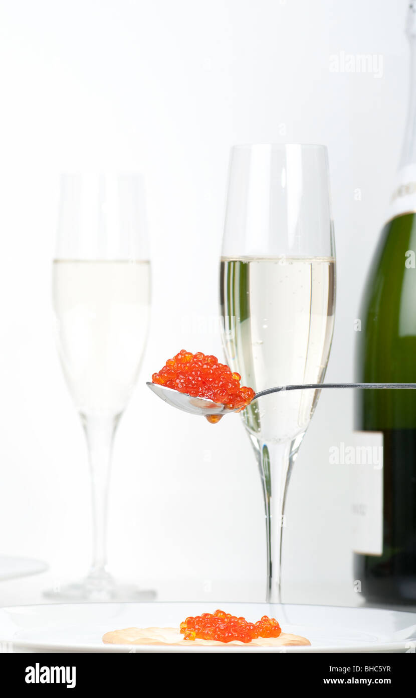 Une cuillère à caviar de saumon en face de la pleine verres de champagne et  une bouteille de champagne. L'accent sur le caviar Photo Stock - Alamy