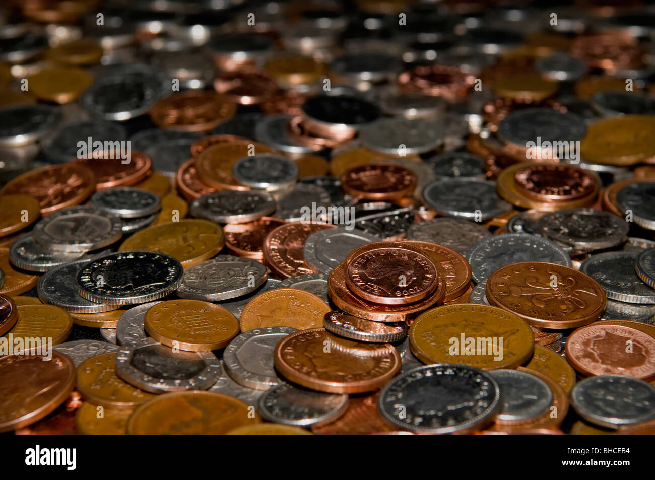 Table pleine de changement lâche en livres sterling sur table sur un fond noir Banque D'Images