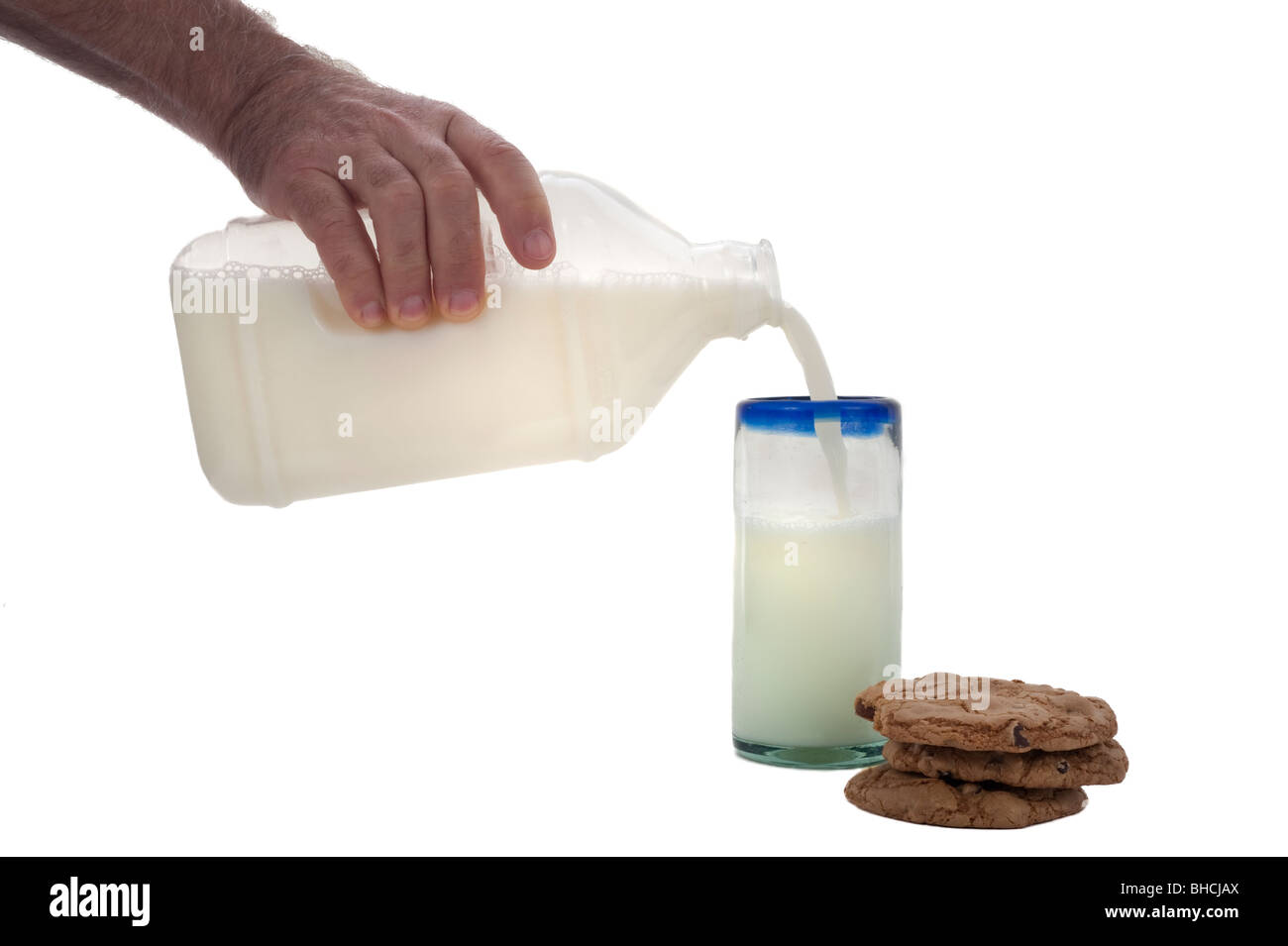 Pile de cookes pépites de chocolat et un verre de lait est versé dans une bouteille. Banque D'Images