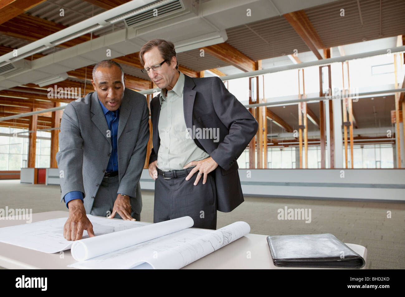 Hommes d'looking at blueprints Banque D'Images