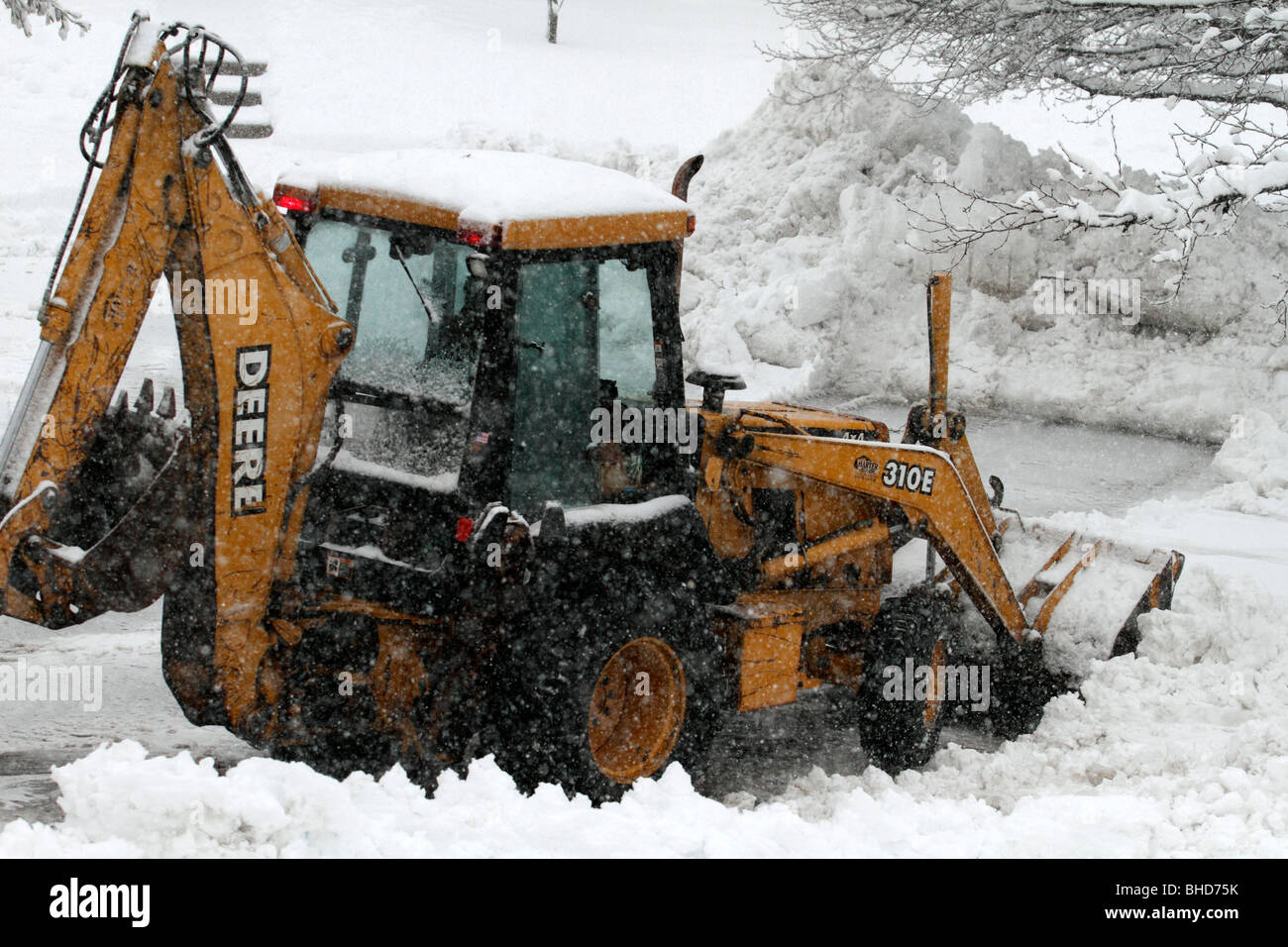 Un chargeur avant de labourer pendant un blizzard de neige Banque D'Images