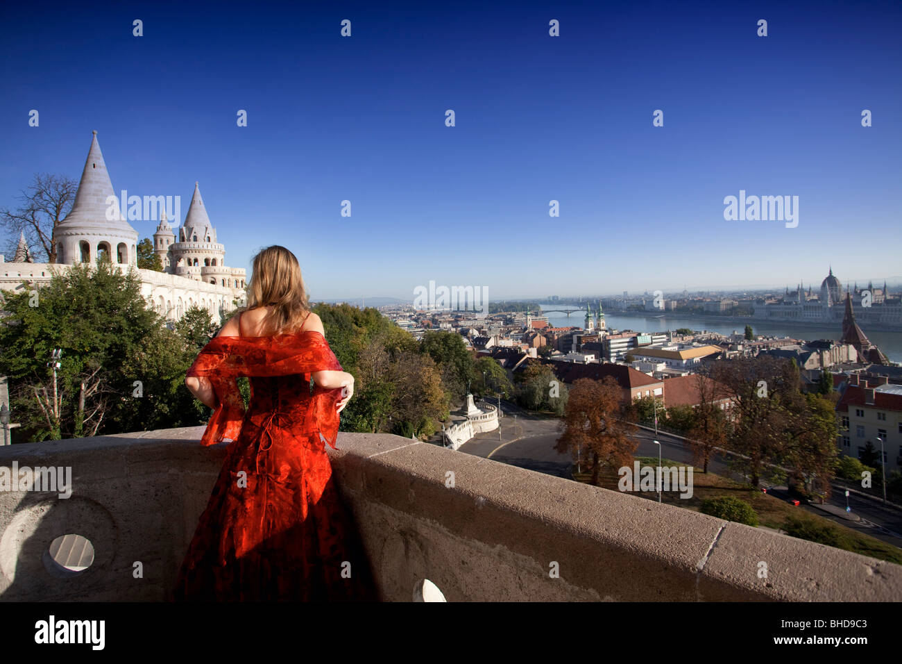 Une fille dans une robe typique magyar du Bastion des Pêcheurs sur un balcon un dimanche matin Banque D'Images