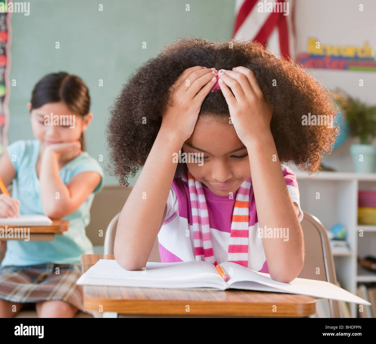 School girl reading book in classroom Banque D'Images