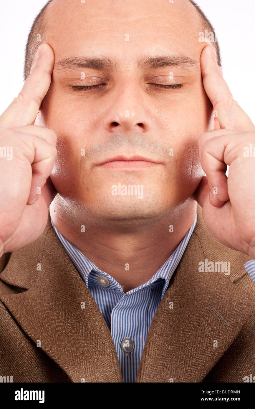 Jeune homme d'affaires avec les yeux fermés et une expression de concentration, isolé sur fond blanc Banque D'Images