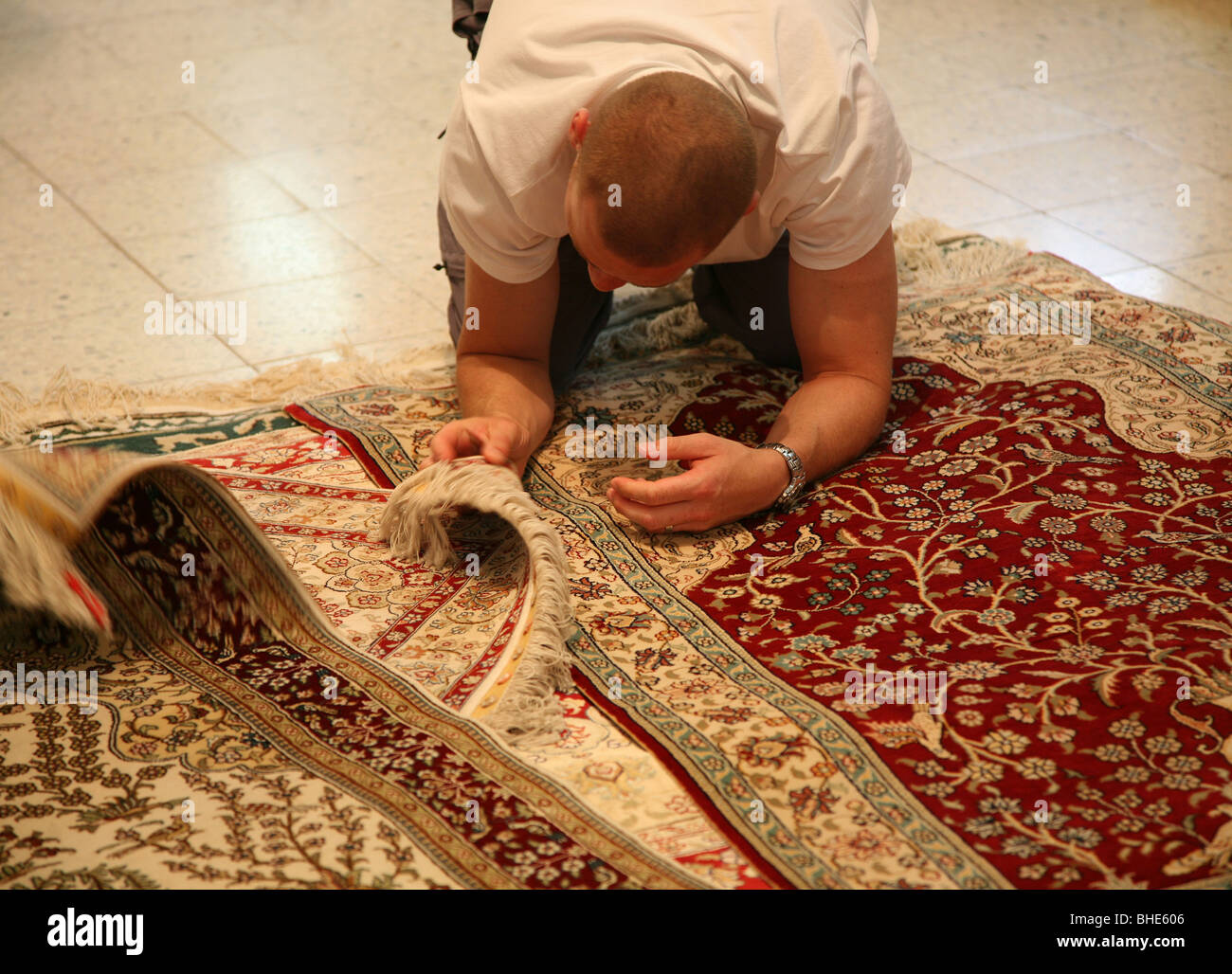 Un homme l'examen de la qualité de la moquette ou un tapis à un prix de  vente à Kairouan Tunisie Afrique du Nord Photo Stock - Alamy