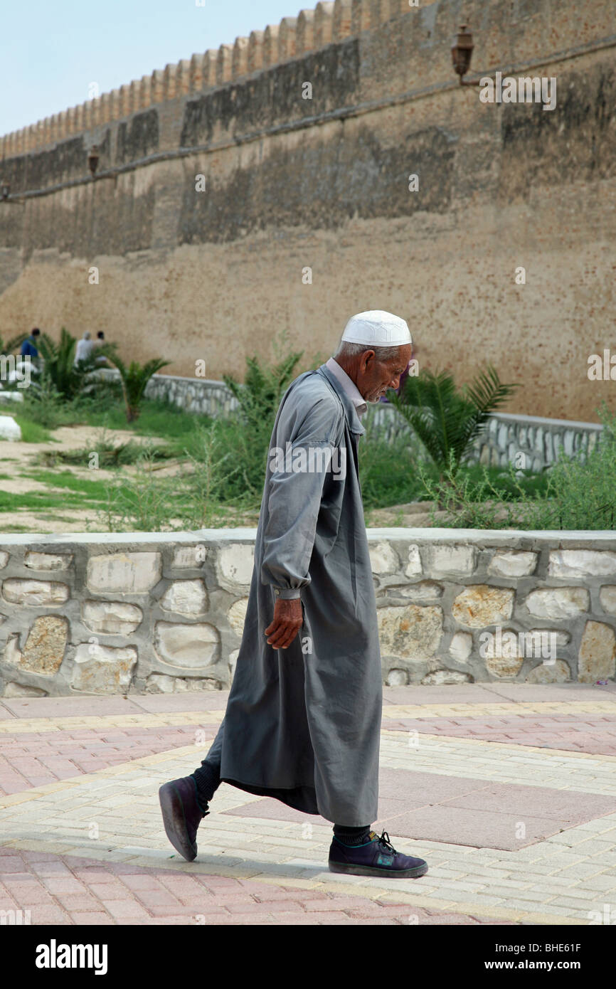 Un homme tunisien en vêtements traditionnels à l'extérieur de la grande mosquée de Kairouan, Tunisie, Afrique du Nord Banque D'Images