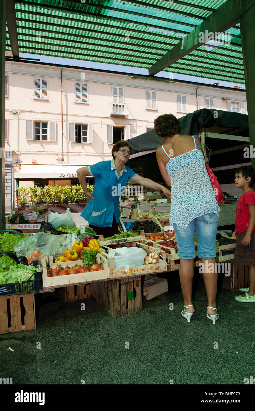 Femme à son échoppe de marché vend des fruits et légumes à Pinerolo. Banque D'Images