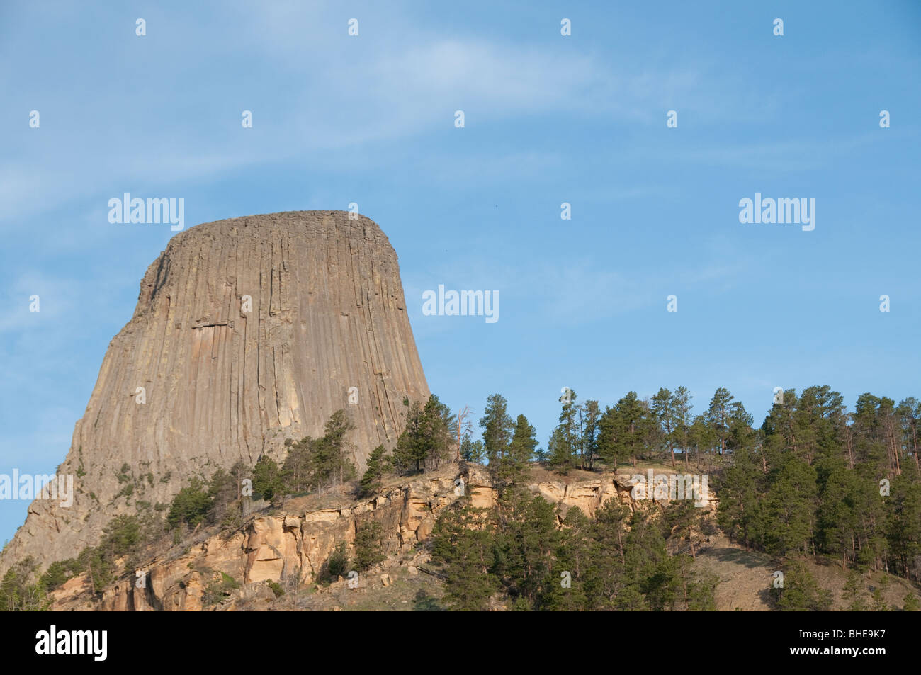 Devils Tower dans le Wyoming contre le ciel bleu avec des arbres le long de l'image de fond Banque D'Images