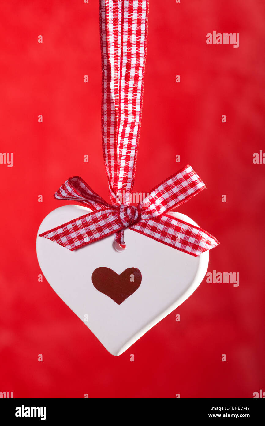 Coeur avec ruban sur fond rouge Banque D'Images