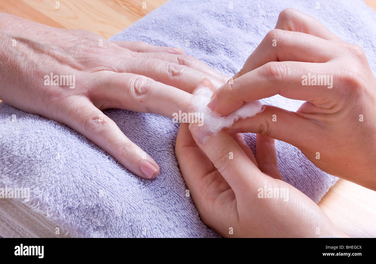 74 ans femme avec mains arthritiques recevant des soins de spa / manucure. Banque D'Images