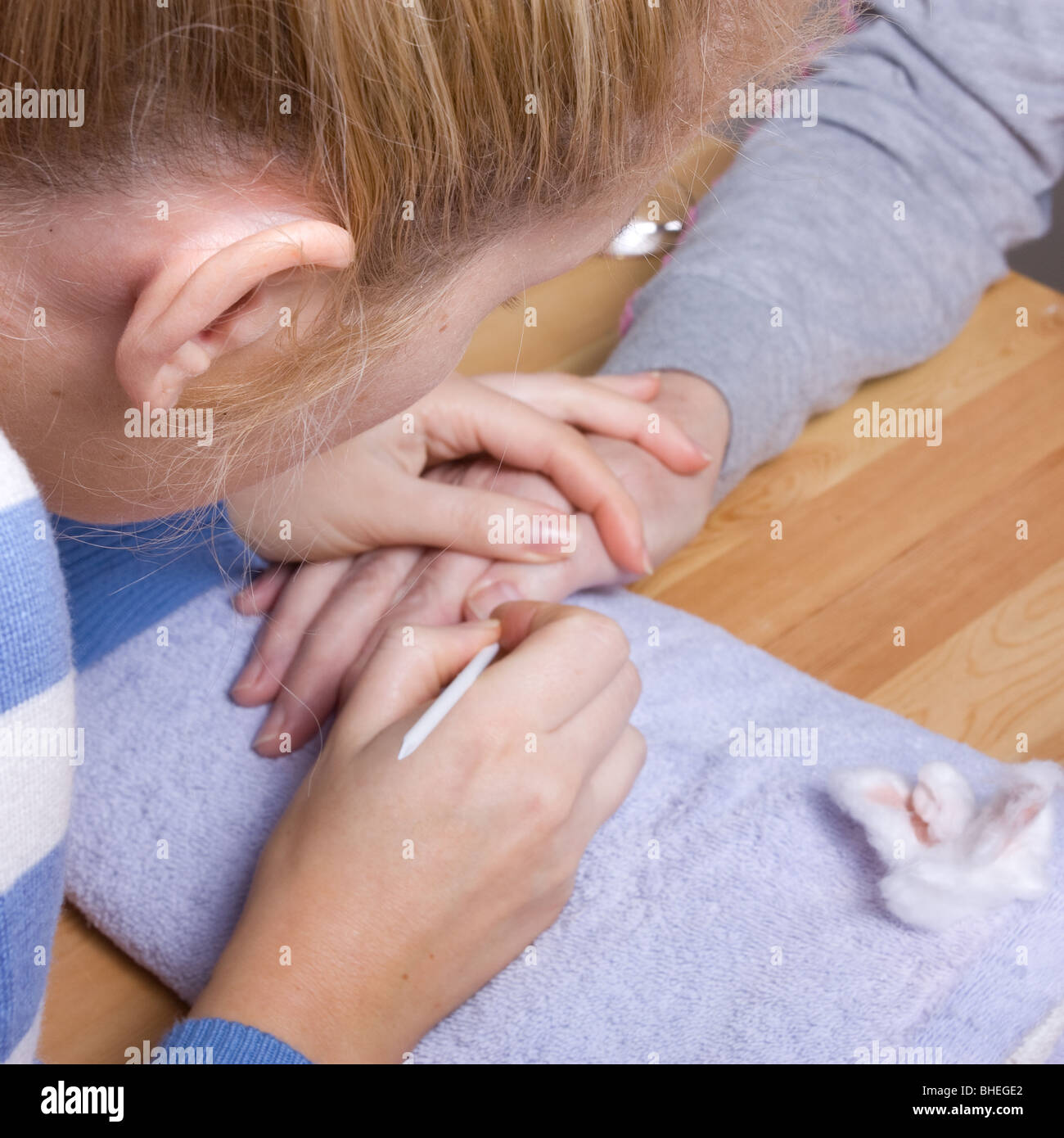 74 ans femme avec mains arthritiques recevant des soins de spa / manucure. Banque D'Images