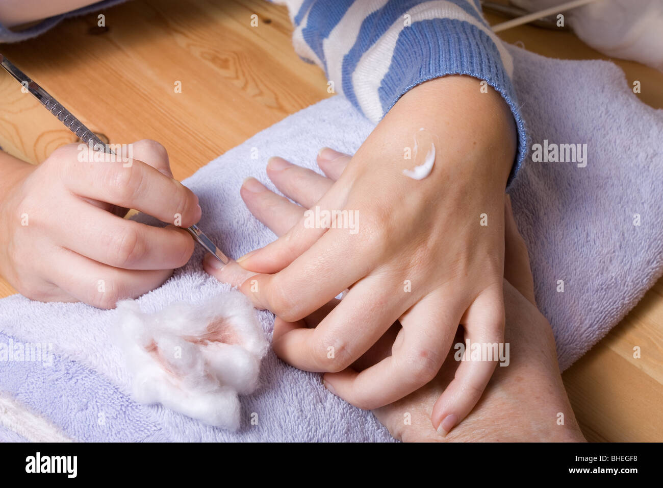 74 ans femme avec mains arthritiques recevant des soins de spa / manucure. Banque D'Images