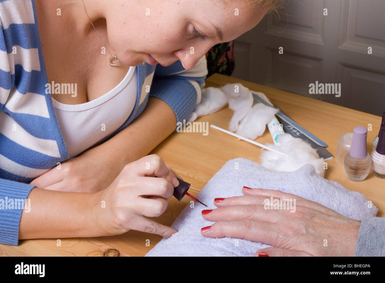 74 ans femme avec mains arthritiques recevant des soins de spa / manucure. Banque D'Images