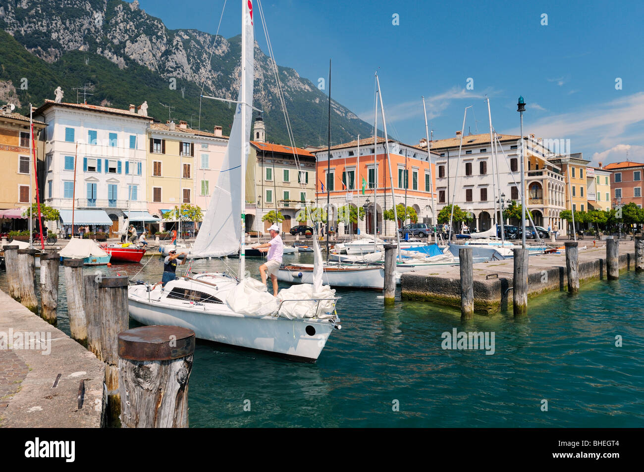 Le village de vacances ville de Gargnano sur le lac de Garde, Lombardie, Italie. La voile de quitter le port. Lago di Garda. Banque D'Images