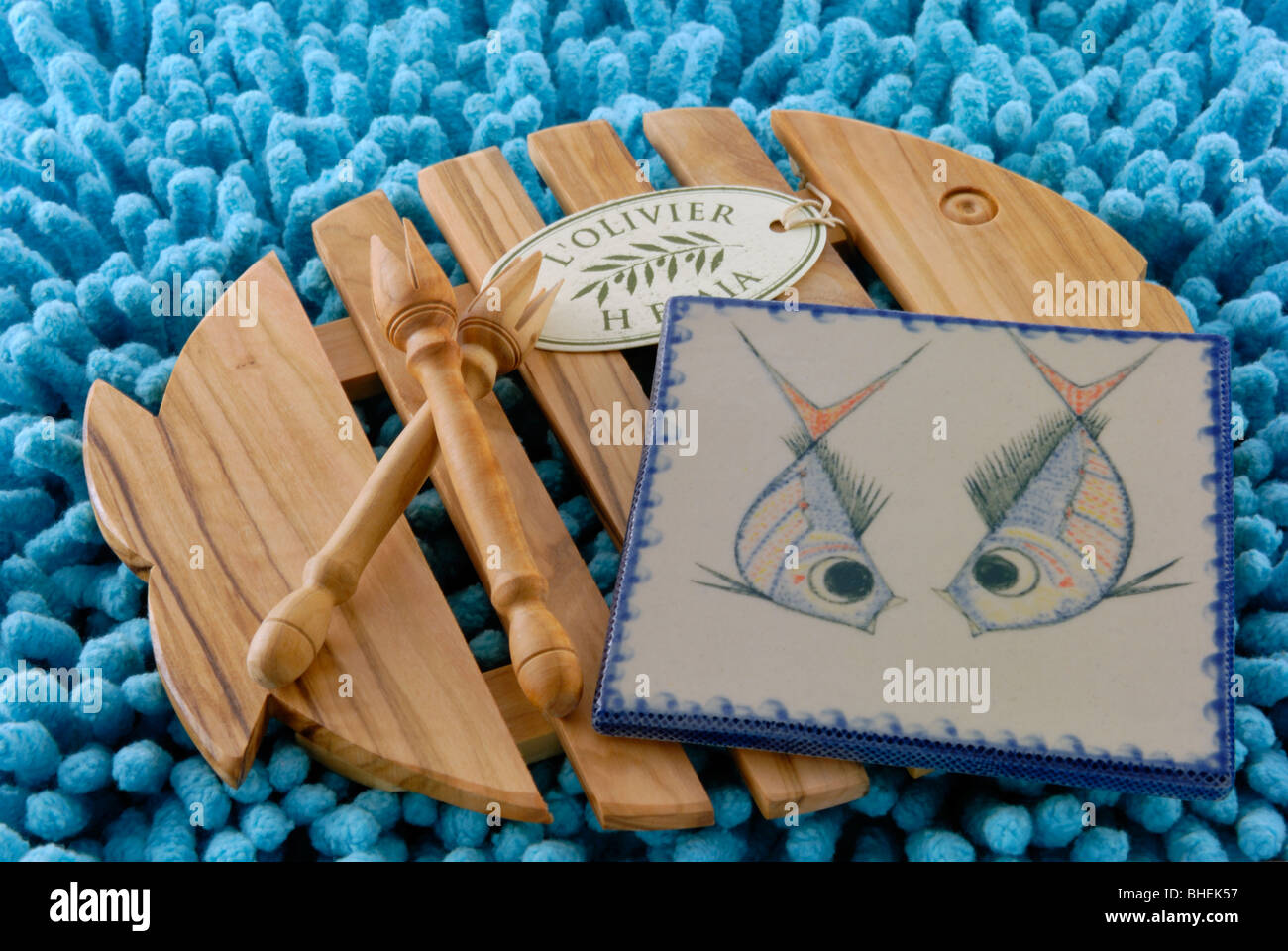 Un sous-plat en bois d'olive en bois, deux fourches et une tuile de céramique d'art de l'Oliver. Le L'Oliver, une galerie en céramique et la boutique est localiser Banque D'Images